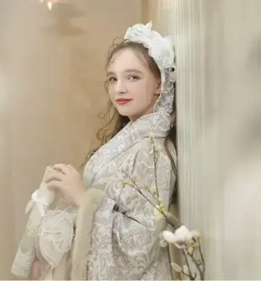レースの髪飾りと淡い色の着物で微笑む女の子