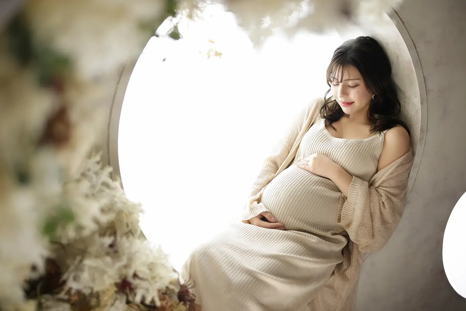 ベージュの衣装を着たマタニティの女性