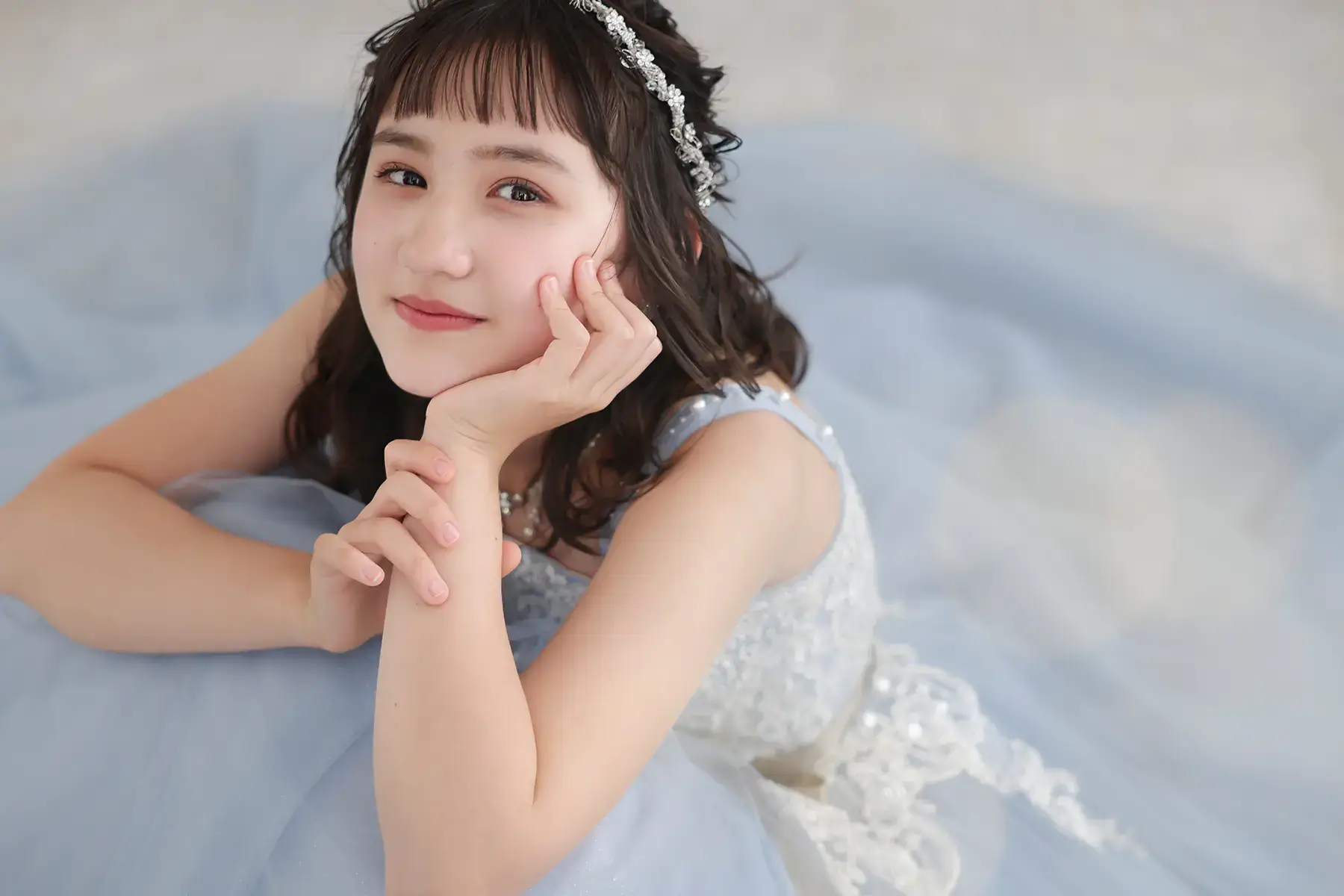 水色のドレスで優雅にポーズをとる十歳の女の子のバースデーフォト