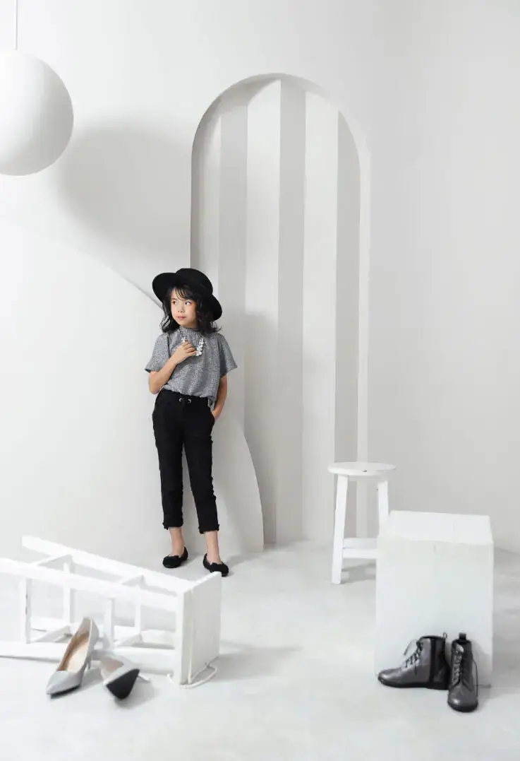 モノトーンの背景で帽子をかぶった女の子がクールにポージング