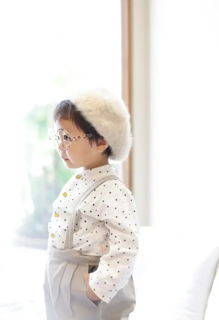 白いベレー帽と眼鏡が可愛い男の子のナチュラルな横顔ポートレート