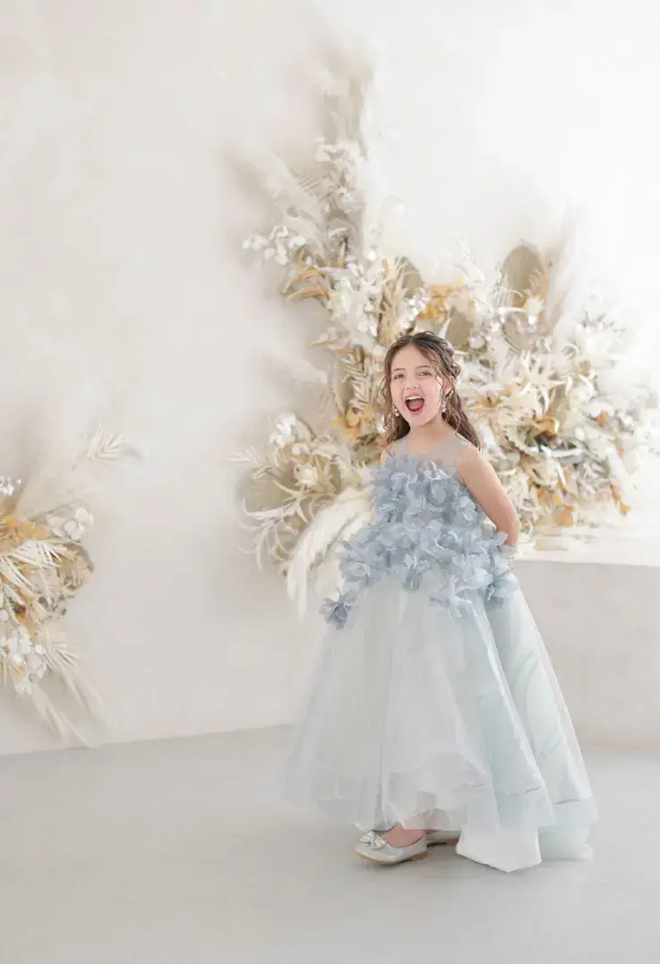 ドライフラワーを背景にブルーのドレスを着た女の子のソロショット