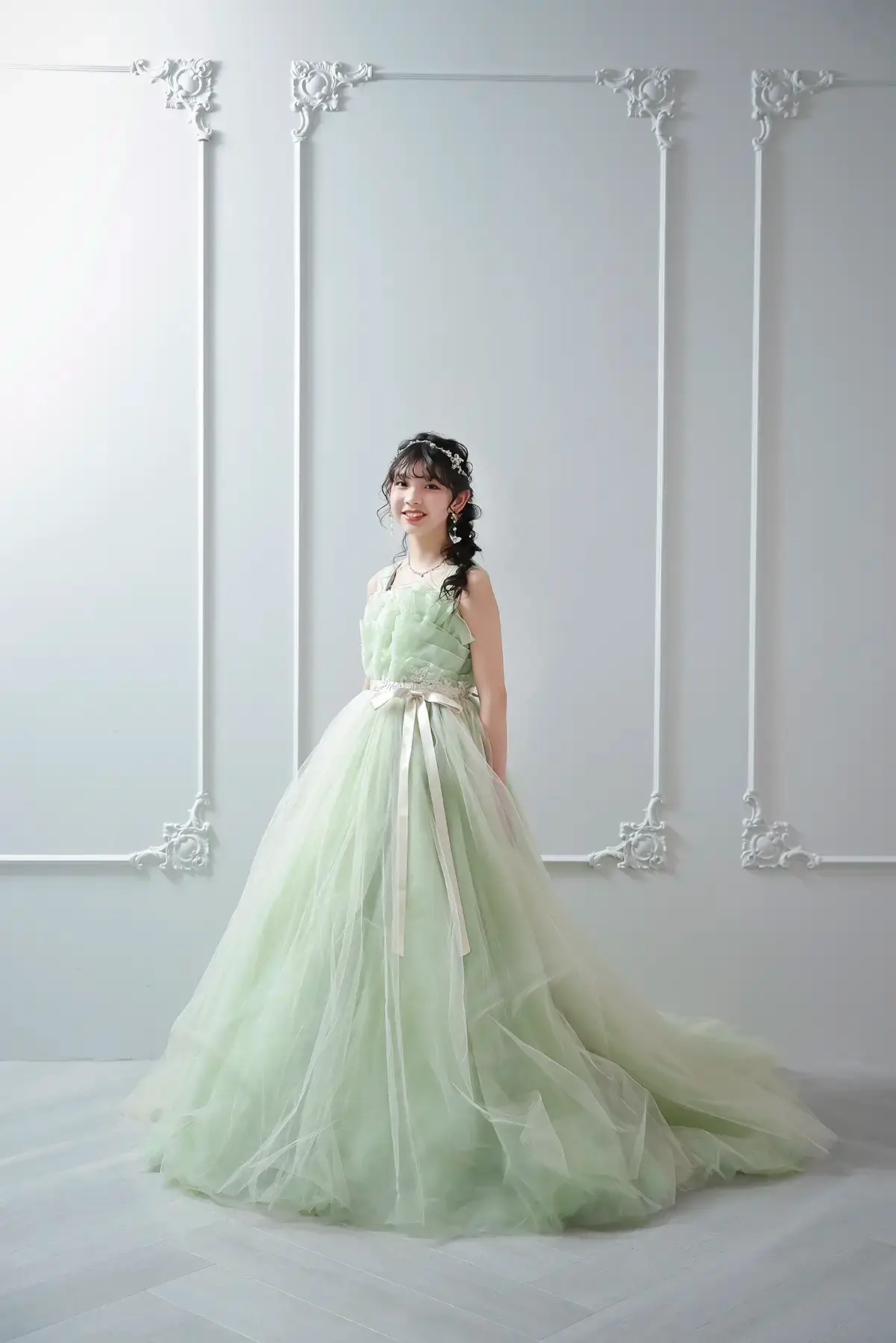 淡いグリーンのドレスを着て微笑む女の子の卒業記念撮影