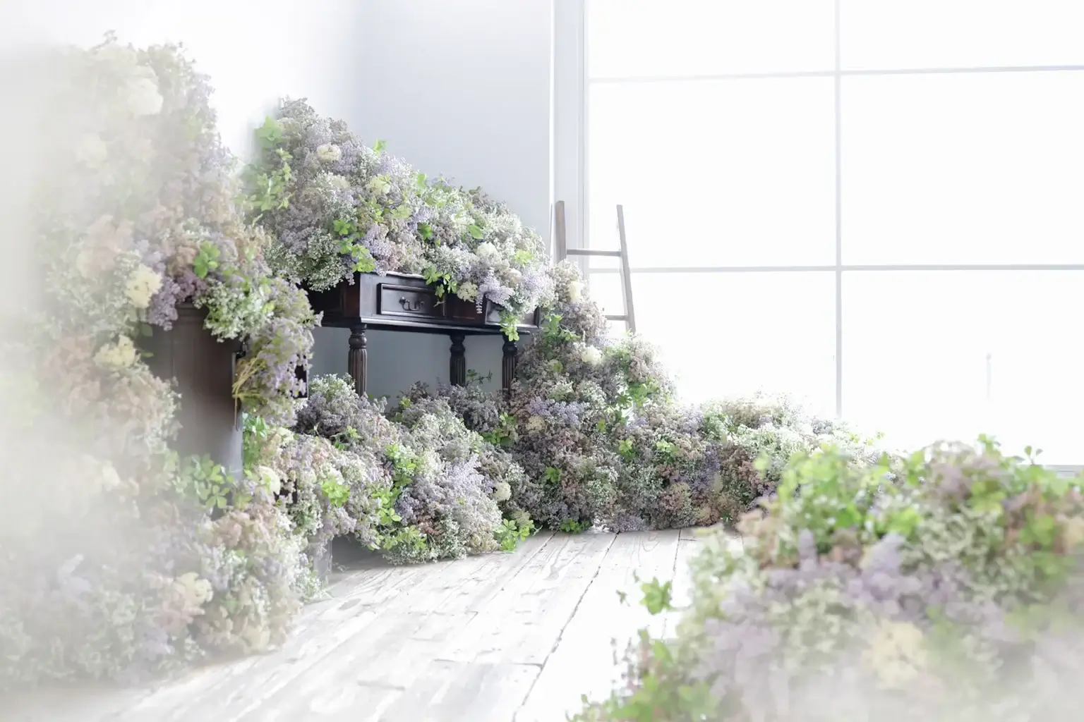 淡い紫とグリーンの花々が床まで広がる華やかな撮影背景