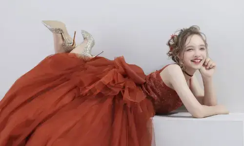 赤いドレスとヒールでポーズを決めるティーンの華やかな写真