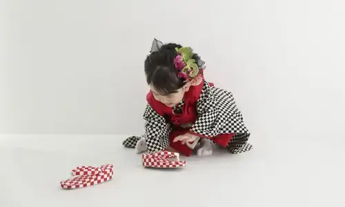 市松模様の着物姿で草履を見つめる女の子の七五三写真