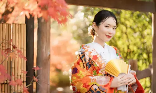 紅葉の中で番傘と扇子を持つ色打掛姿の和装花嫁