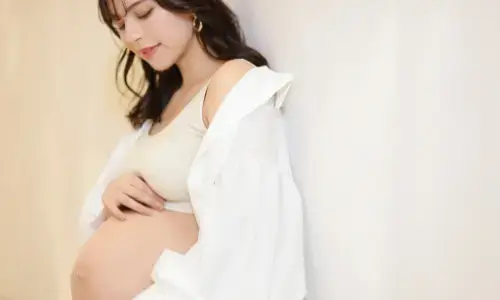 壁にもたれ微笑む妊婦の自然なポートレート