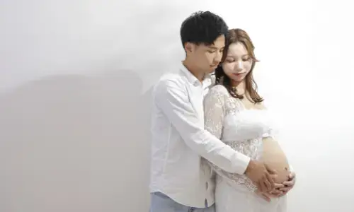 夫婦でお腹に手を添える温かなマタニティ撮影