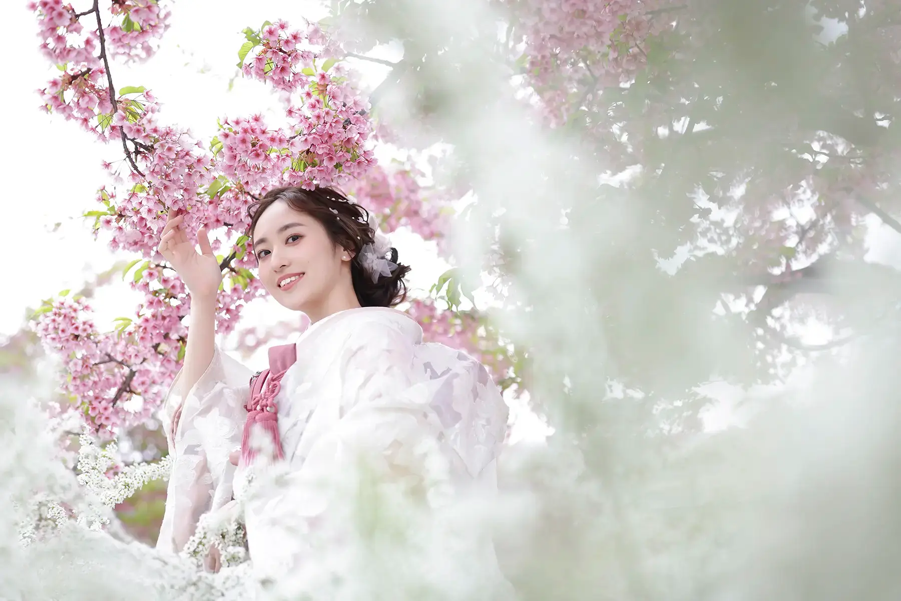 満開の桜の下で和装姿の花嫁が微笑む春のロケーションフォト