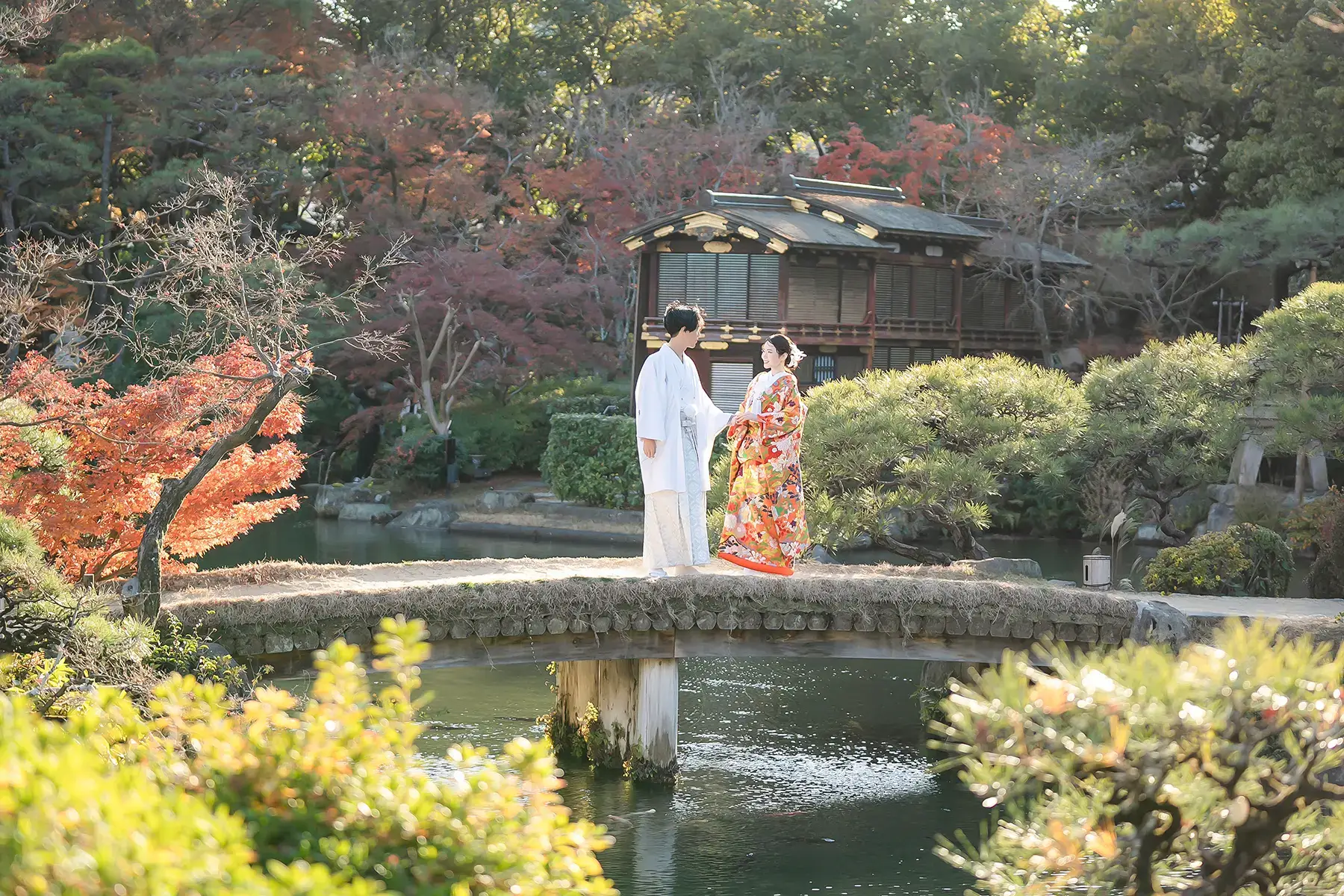日本庭園の橋の上で見つめ合う新郎新婦の和装ロケーションフォ