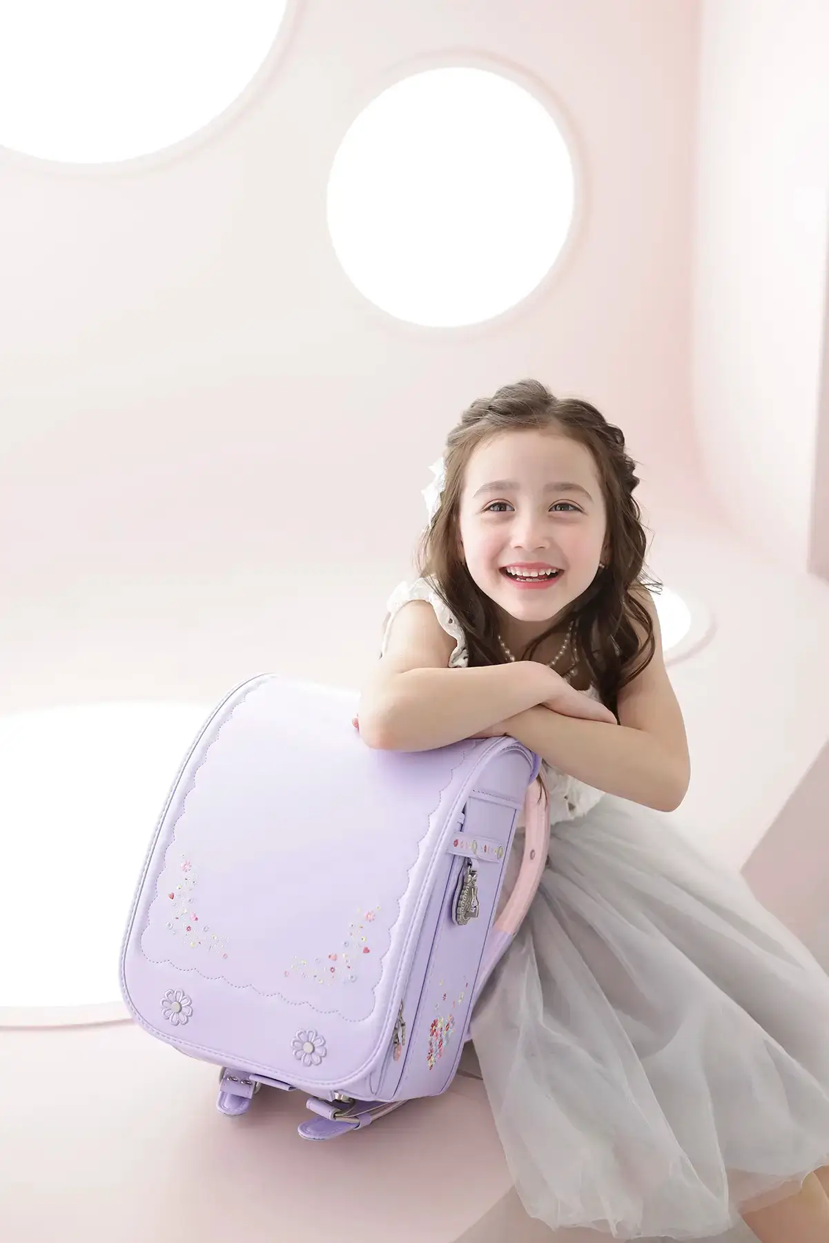 ラベンダー色のランドセルに寄り添う笑顔の女の子